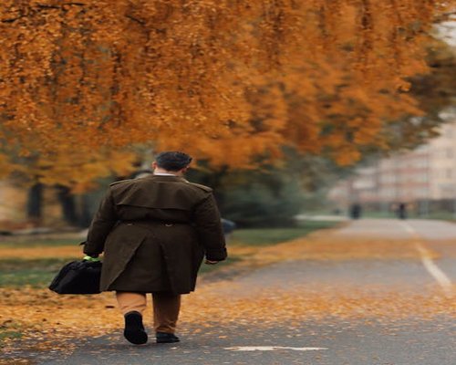 Mężczyzna idący z pracy przez jesienny park